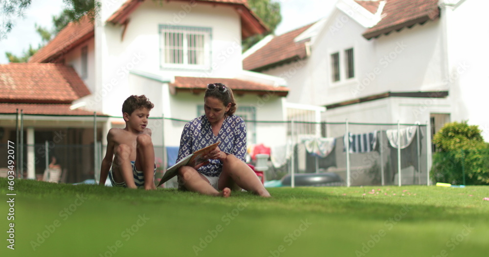 Fototapeta premium Candid mother studying homework with child son outside