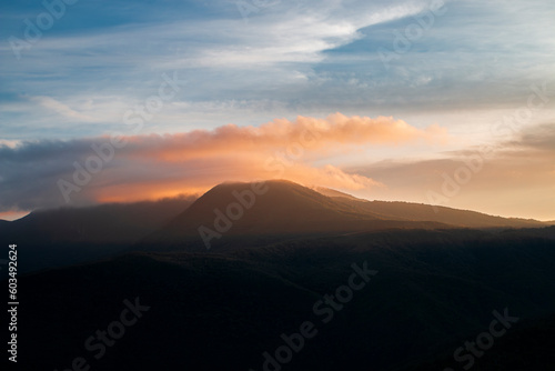 Nascer do sol iluminando nuvem em cima do Pico