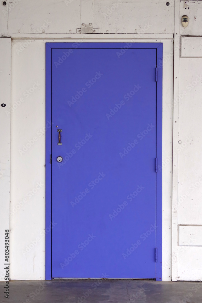 New blue steel door on the back of an old warehouse New blue steel door on the back of an old warehouse