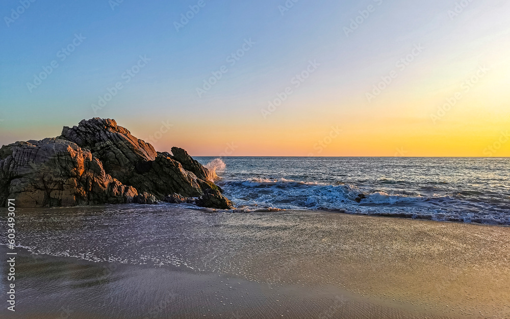 Surfer waves turquoise blue water rocks cliffs boulders Puerto Escondido.