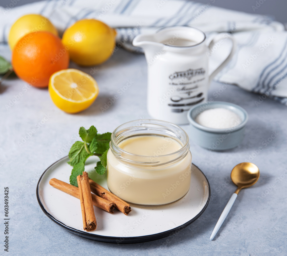Delicious panna cotta or vanilla pudding with citrus fruits in a jar on a light background with ingredients. Homemade healthy sweet food Delicious panna cotta or vanilla pudding with citrus fruits in a jar on a light background with ingredients. Homemade healthy sweet food