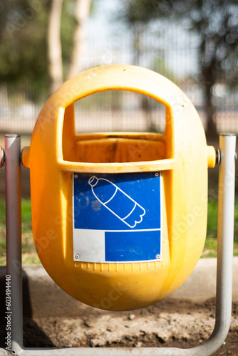 yellow recycling bin in a pubblic yard photo