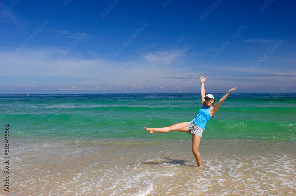 Beautiful happy woman spreading water on the beach Beautiful happy woman spreading water on the beach