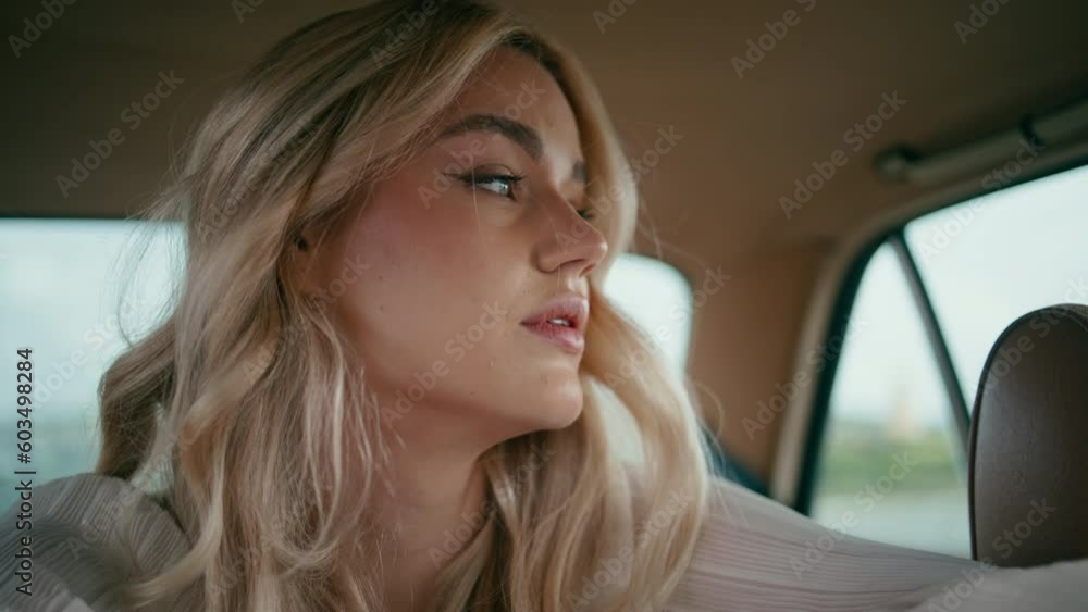 Closeup girl sitting car back seat looking outside. Woman posing in retro auto.
