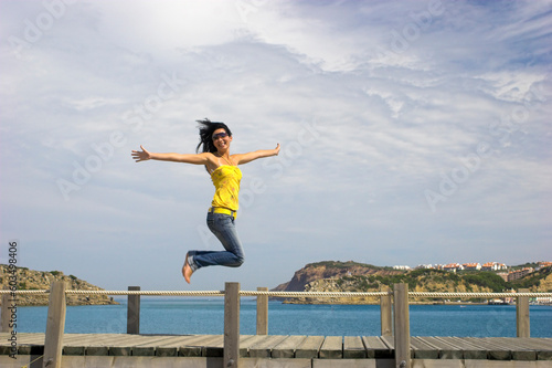 Young and beautiful woman jumping on a beach background