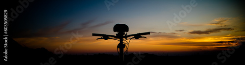 Beautiful landscape image with Bicycle at sunrise. Composition with bicycle and landscape. Bicycle handlebars on the background of the sky.