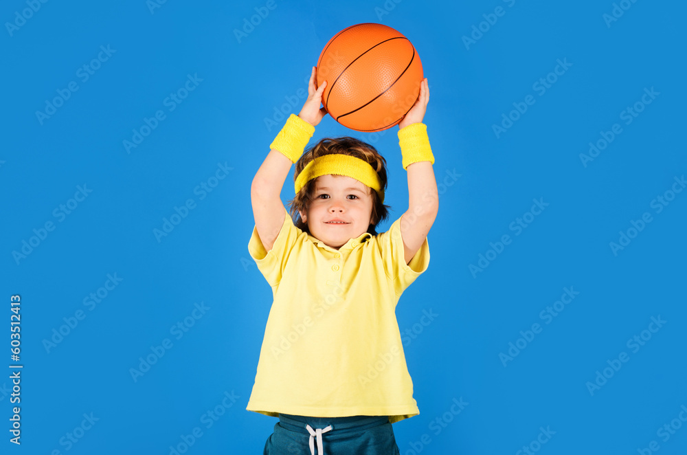 Little basketballer throwing basketball ball. Sportive child boy in uniform playing basketball. Professional sport. Basketball training. Smiling basketball player with game ball. Healthy lifestyle. Little basketballer throwing basketball ball. Sportive child boy in uniform playing basketball. Professional sport. Basketball training. Smiling basketball player with game ball. Healthy lifestyle.