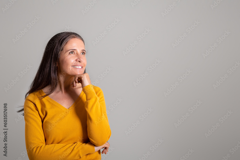 Smiling pensive pretty old european woman looks at empty space, thinks over ad and offer Smiling pensive pretty old european woman looks at empty space, thinks over ad and offer