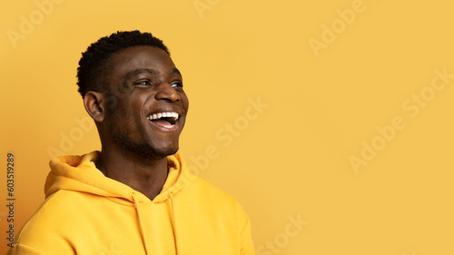Joyful young african guy looking at copy space and laughing