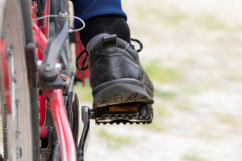 Men's foot on the bicycle pedal.The concept of cycling, active lifestyle. Men's foot on the bicycle pedal.The concept of cycling, active lifestyle.
