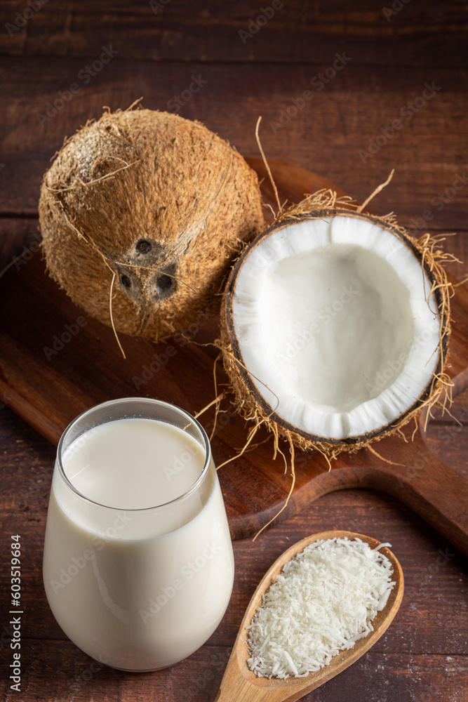 Glass of coconut milk with pieces of coconut on the table. Glass of coconut milk with pieces of coconut on the table.