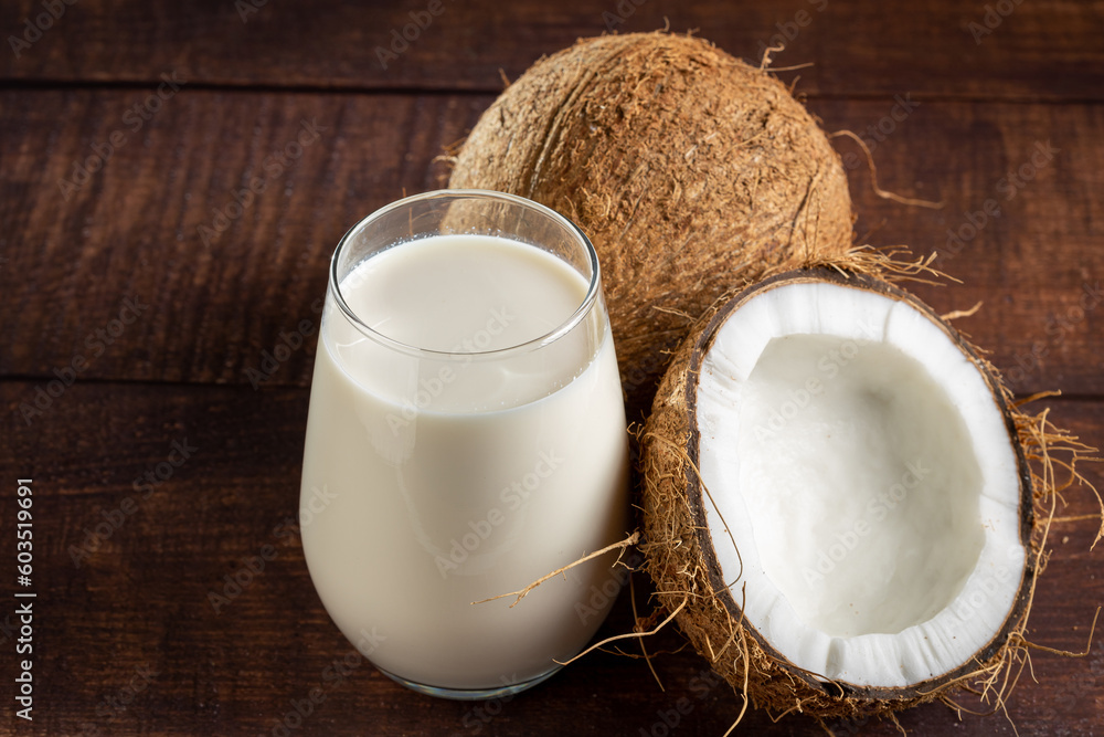 Glass of coconut milk with pieces of coconut on the table. Glass of coconut milk with pieces of coconut on the table.