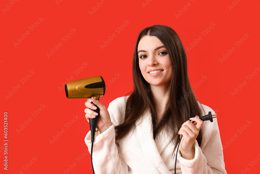 Beautiful young woman with hair dryer on red background Beautiful young woman with hair dryer on red background
