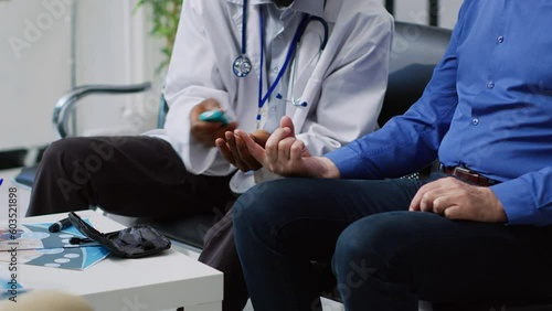 Physician doing insulin level measurement with medical instrument to help asian patient with diabetes during checkup visit appointment in hospital waiting room. Medicine support service photo