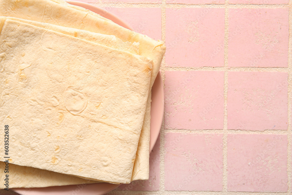 Plate with fresh lavash on pink tile background Plate with fresh lavash on pink tile background