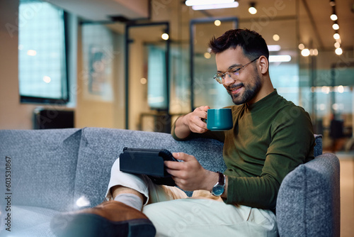 Photography Happy businessman surfing the net on touchpad during coffee break in office