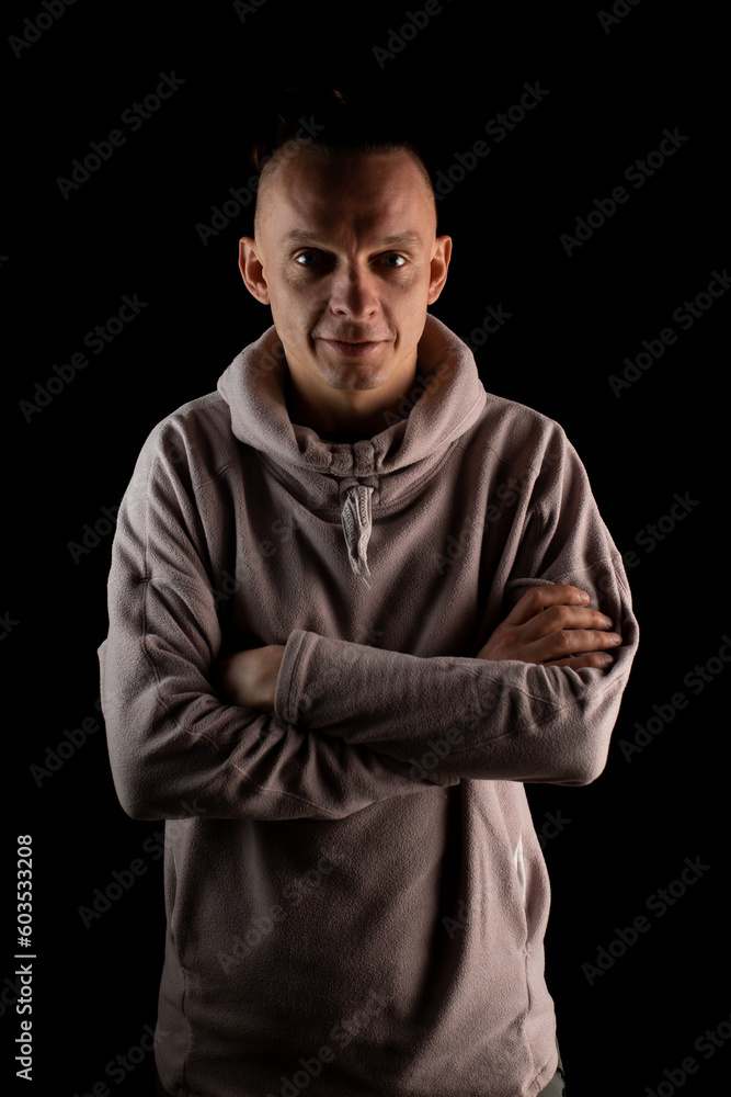 Slim confident man on a black background. Casual clothes. Crossed arms. Psychologist, personal growth coach. Slim confident man on a black background. Casual clothes. Crossed arms. Psychologist, personal growth coach.