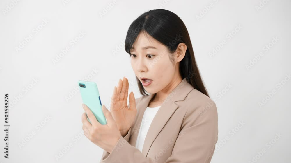 スマートフォンを持ちながらビックリをする若い女性	
