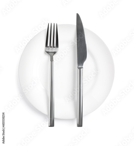 Clean plate with shiny cutlery on white background, top view