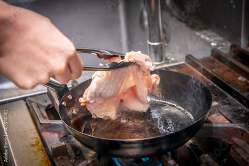 chef cooks chicken 厨房で鶏肉を炒めている