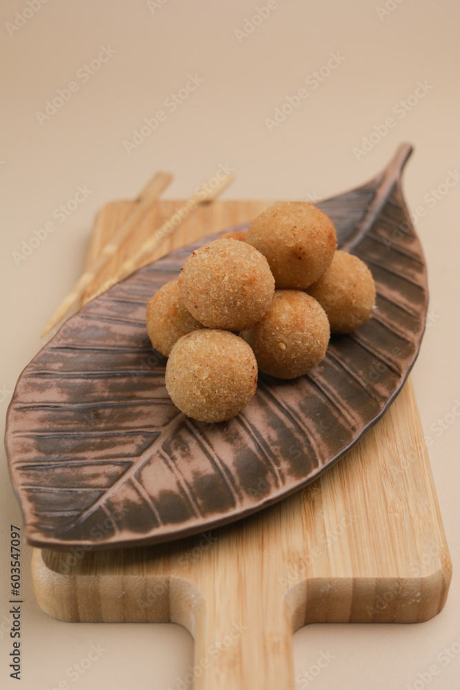 Potato croquettes, piled on ceramic container, isolated on beige background Potato croquettes, piled on ceramic container, isolated on beige background
