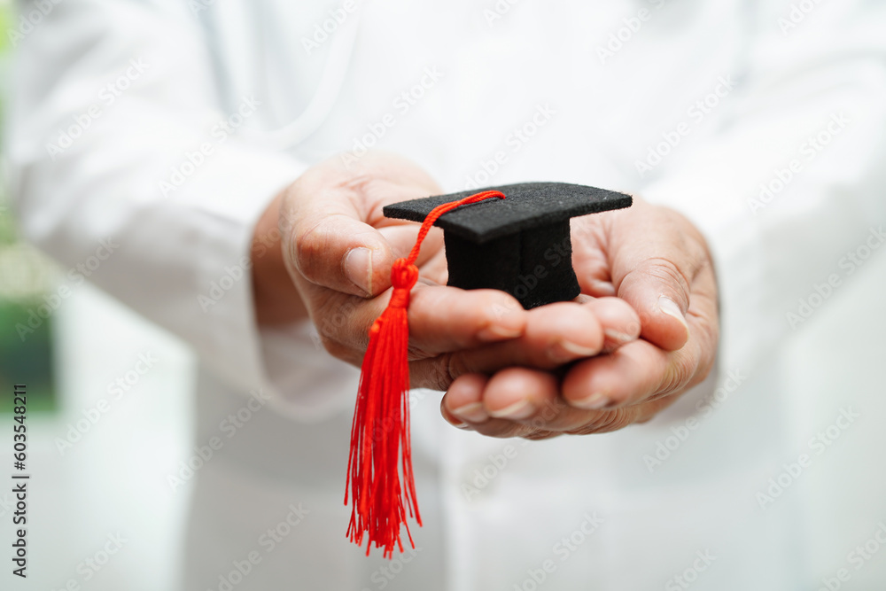 Fototapeta premium Asian woman doctor holding graduation hat in hospital, Medical education concept.