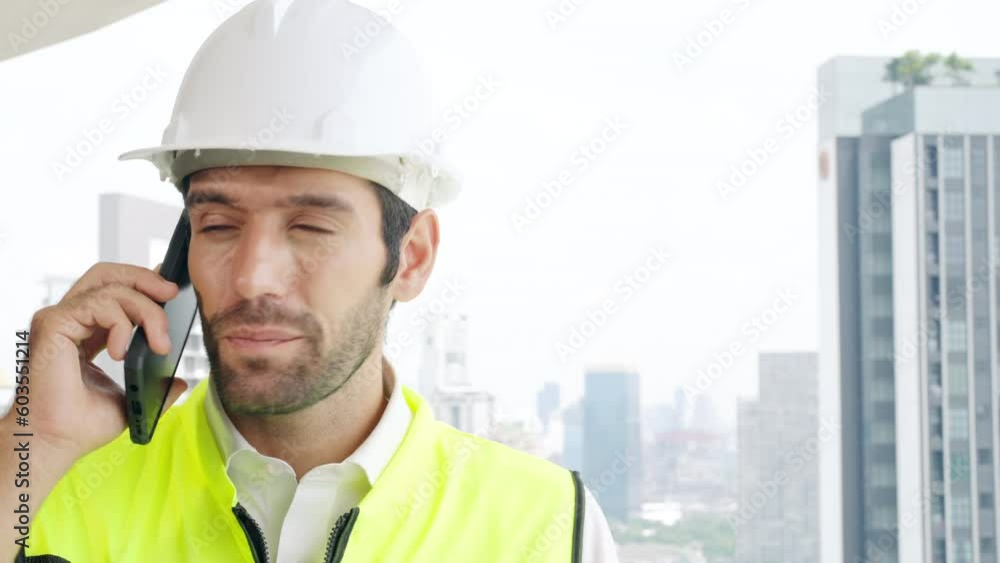 Male civil engineer contractor in safety helmet and jacket standing on construction site building and using mobile phone talking discussion real estate development working plan with architect manager