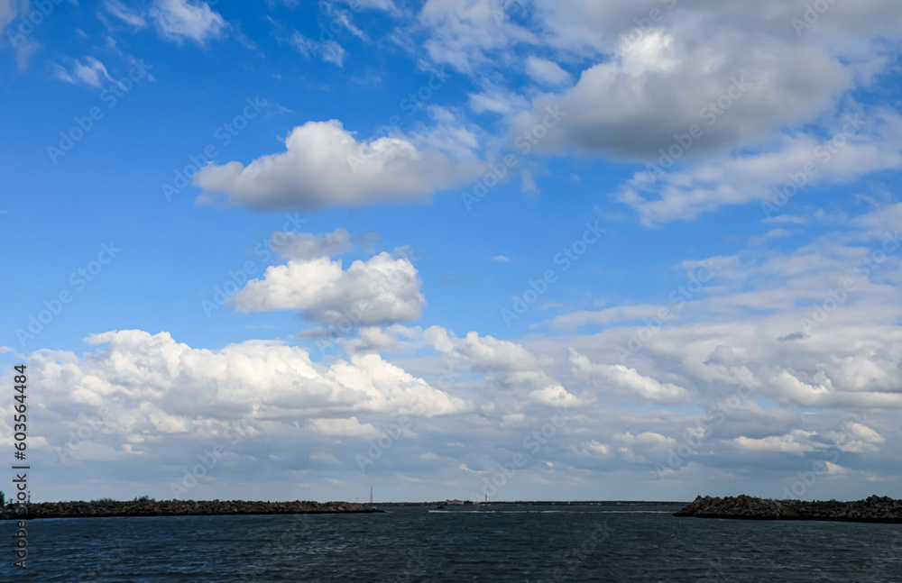 Obraz premium On a sunny day, a panoramic view of the beautiful seascape and the blue sky with white clouds.