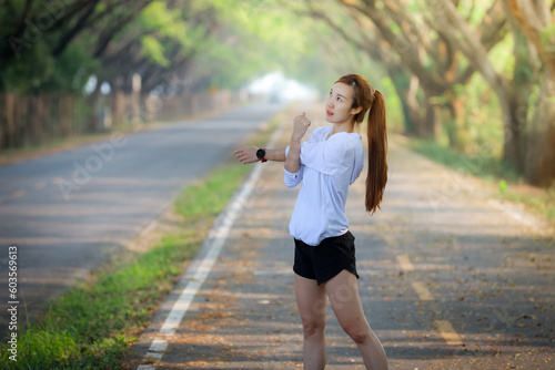 young woman relax in garden road evening ,woman fitness silhouette sunrise jogging workout wellness concept. 