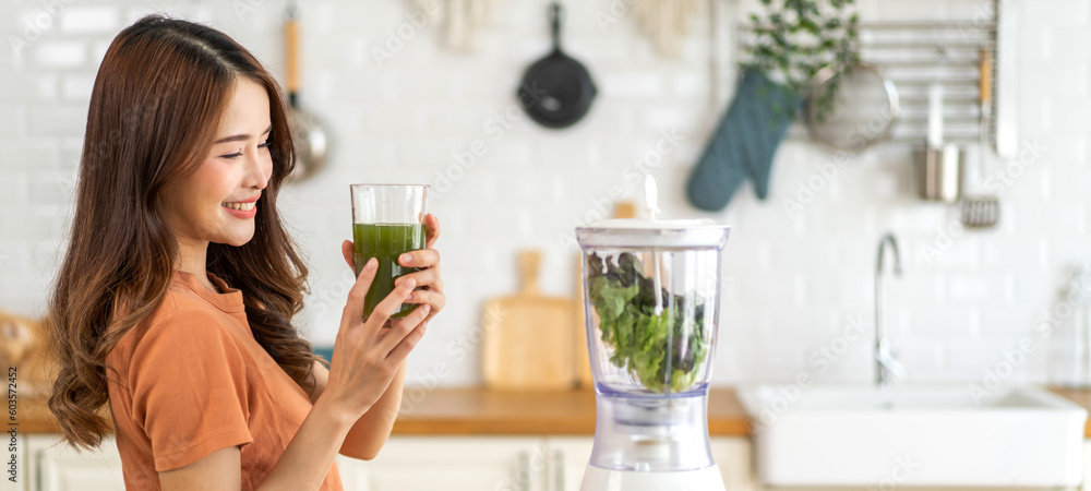 Portrait of beauty healthy asian woman making green vegetables detox cleanse and green fruit smoothie with blender.young girl drinking glass of green fruit smoothie in kitchen.Diet concept.healthy Portrait of beauty healthy asian woman making green vegetables detox cleanse and green fruit smoothie with blender.young girl drinking glass of green fruit smoothie in kitchen.Diet concept.healthy
