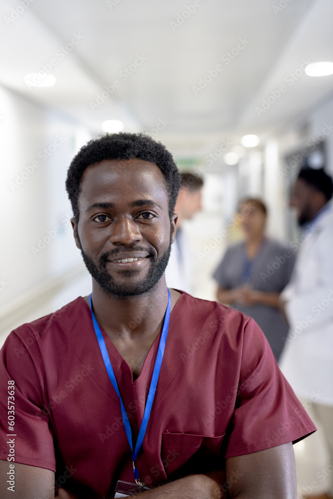 Portrait of happy african american male doctor with arms crossed over diverse colleagues Portrait of happy african american male doctor with arms crossed over diverse colleagues