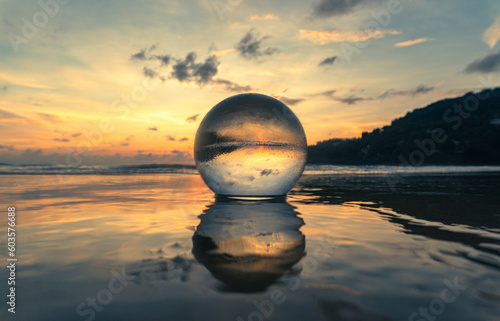 Magnificent sky above the crystal ball on the beach..The beautiful reflection of the sky above the crystal ball on the wet sand beach..Unique and creative travel and nature idea © Narong Niemhom