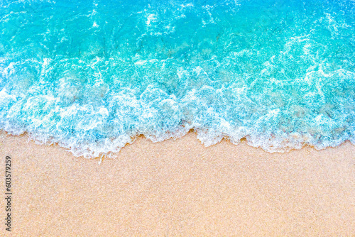 Soft blue ocean wave on sandy beach. Summer background