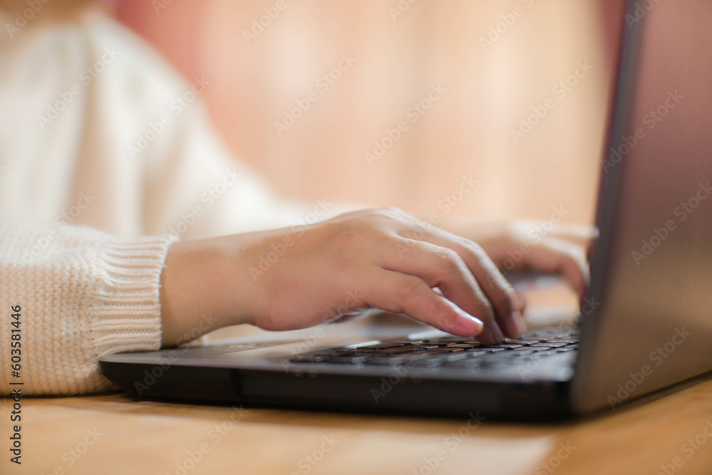 Woman sitting at desk and working on laptop in office at home close-up. Close up of woman hand using laptop sitting in office and doing research. Woman sitting at desk and working on laptop in office at home close-up. Close up of woman hand using laptop sitting in office and doing research.