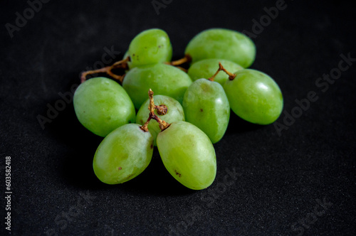 Fresh green grapes picked from the tree on a black background