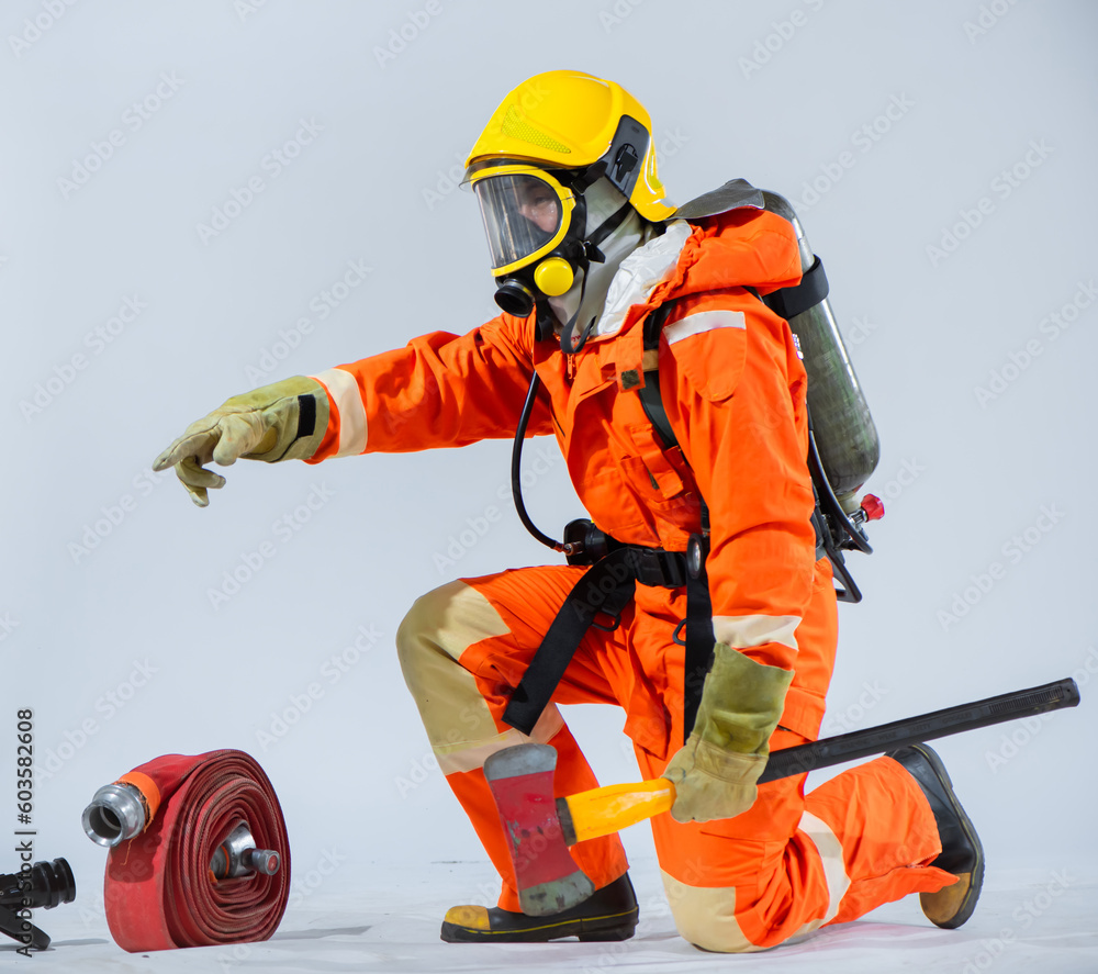 The firefighter sits sideways while holding an iron ax in his hand and pointing finger on a white background The firefighter sits sideways while holding an iron ax in his hand and pointing finger on a white background