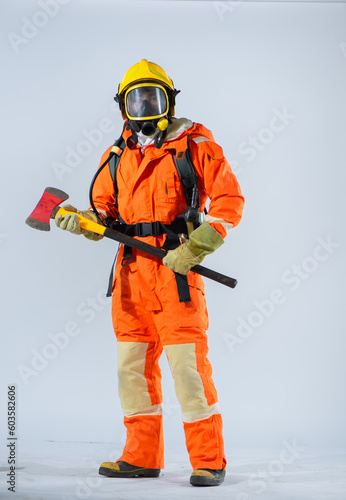 Firefighter standing and holding iron ax with both hands in white background.