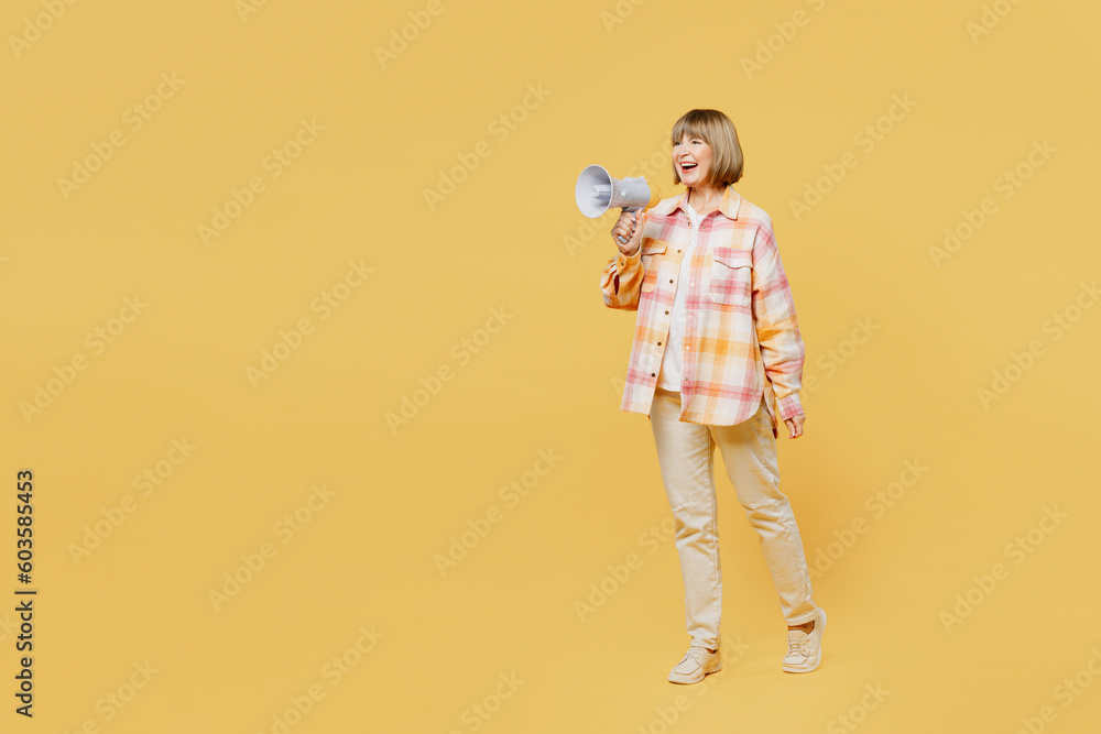 Full body elderly surprised shocked blonde woman 50s years old wear casual clothes hold in hand megaphone scream announces discounts sale Hurry up isolated on plain yellow background studio portrait. Full body elderly surprised shocked blonde woman 50s years old wear casual clothes hold in hand megaphone scream announces discounts sale Hurry up isolated on plain yellow background studio portrait.