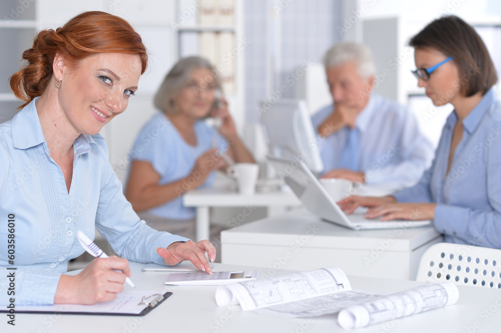 business woman working in office, her colleagues on background business woman working in office, her colleagues on background