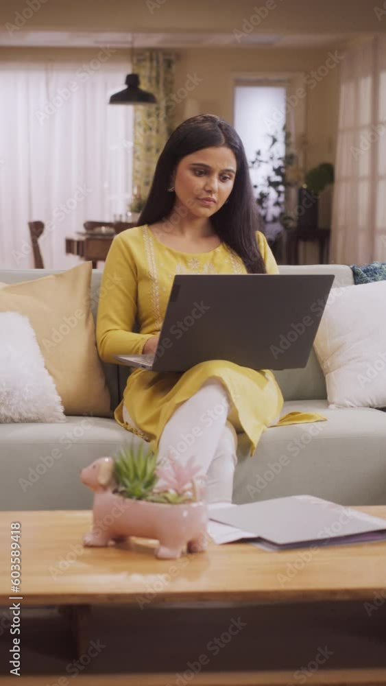 Vertical Screen: Beautiful Indian Woman Using Laptop at Home, Focused on Remote Work Tasks and Managing Team. She Enjoys Online Shopping, Exploring Sales and Discounts to Find Perfect Clothing Deals Vertical Screen: Beautiful Indian Woman Using Laptop at Home, Focused on Remote Work Tasks and Managing Team. She Enjoys Online Shopping, Exploring Sales and Discounts to Find Perfect Clothing Deals