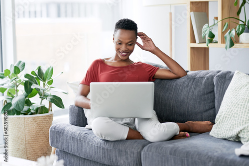 Happy, black woman and relax with laptop on a sofa, comfortable and chilling on the weekend. Streaming, smile and African female person online for internet, search and subscription in a living room