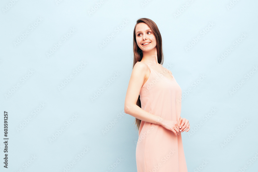 Portrait of young winsome woman in romantic attire pretty smiling on blue background. Slim female in pure pink dress posing in studio. Cheerful model. Isolated. Long hair Portrait of young winsome woman in romantic attire pretty smiling on blue background. Slim female in pure pink dress posing in studio. Cheerful model. Isolated. Long hair