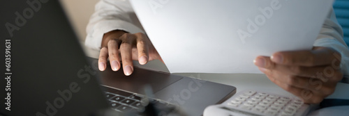 Alone Working Late at Night.Asian business man at workplace in office holding his head on hands after late night work at a desk in a dark office working on a laptop late in the evening concept