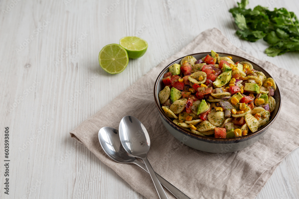 Homemade Grilled Corn Summer Pasta Salad in a Bowl on a white wooden background, low angle view. Copy space. Homemade Grilled Corn Summer Pasta Salad in a Bowl on a white wooden background, low angle view. Copy space.