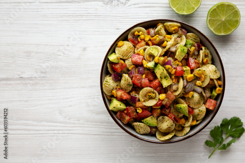 Homemade Grilled Corn Summer Pasta Salad in a Bowl on a white wooden background, top view. Flat lay, overhead, from above. Copy space.