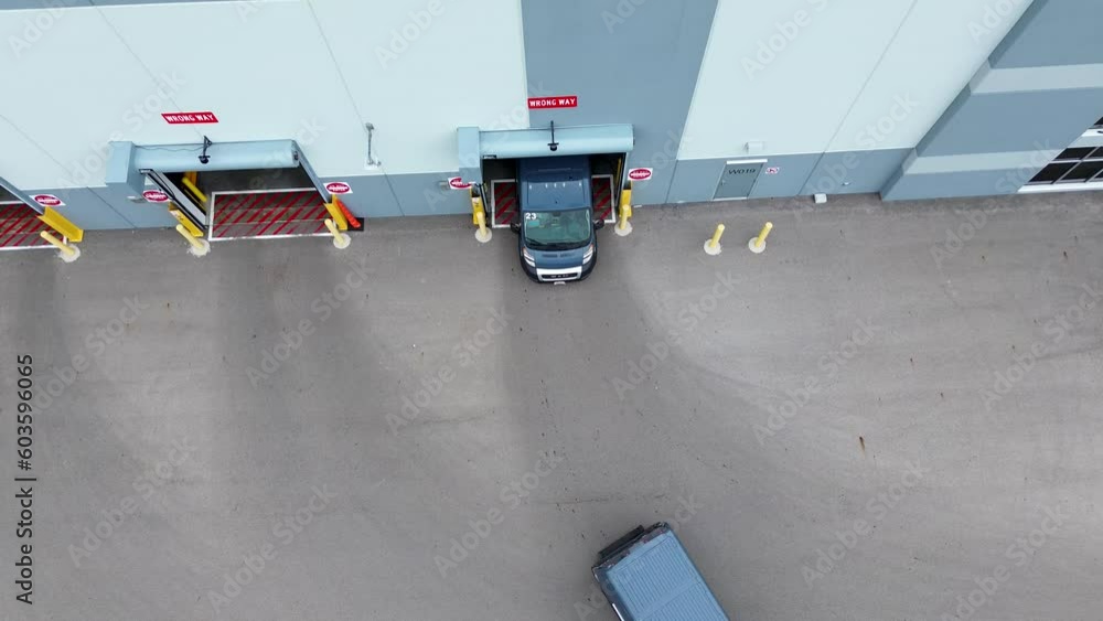 Amazon Vans pull out of Amazon warehouse, aerial drone, straight down