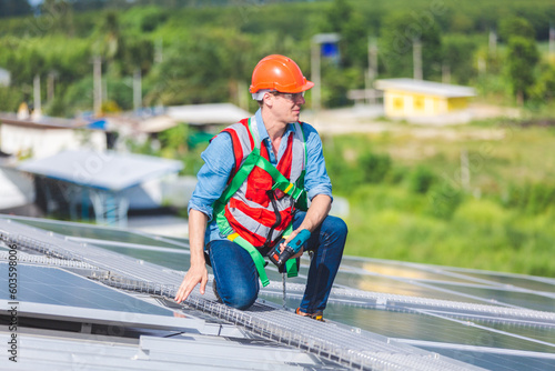 Male professional engineer installing solar photovoltaic panel system, Electrician mounting blue solar module technology on power industrial factory roof, Alternative energy ecological technician job