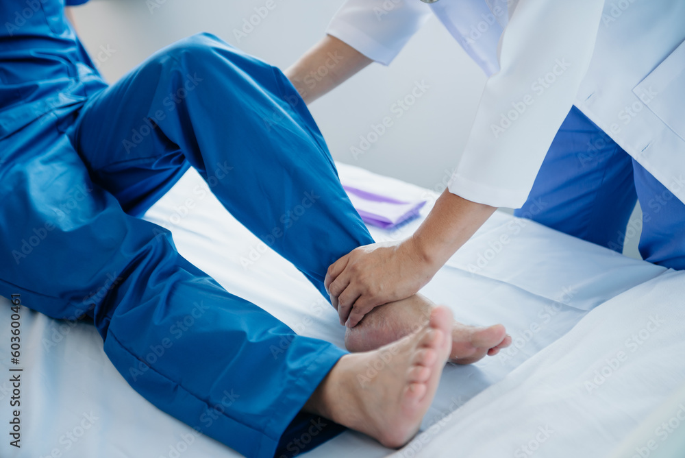 Physiotherapist Helping Patient While Stretching His Leg in bed in clinic . Physiotherapist Helping Patient While Stretching His Leg in bed in clinic .