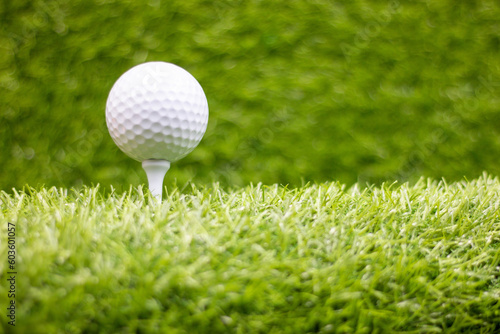 Golf ball on tee is on green grass
