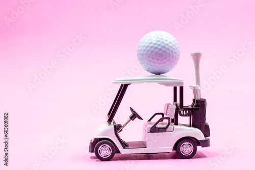Golf cart with ball on the roof on pink background for golfer 